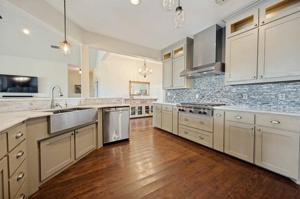 8400 Holder Road, Northlake, TX 76247 Kitchen featuring hardwood-finish flooring, light-toned cabinetry with pulls, stainless steel appliances, a farmhouse sink, and a mosaic tile backsplash