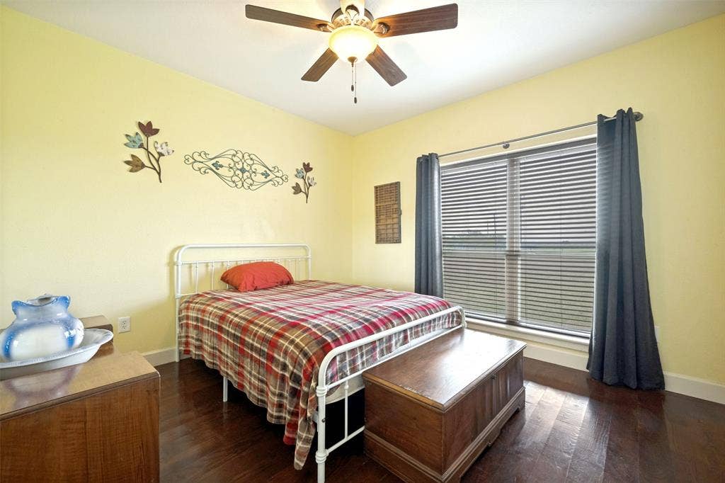 8400 Holder Road, Northlake, TX 76247 Yellow-painted walls, wood-finish flooring, and a ceiling fan with light fixture
