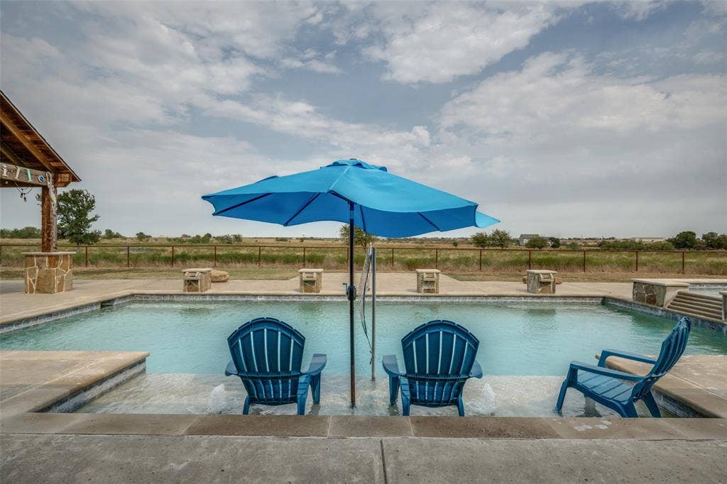 8400 Holder Road, Northlake, TX 76247 Rectangular inground pool with integrated sun shelf, adjacent spa with stone surround, and expansive concrete decking