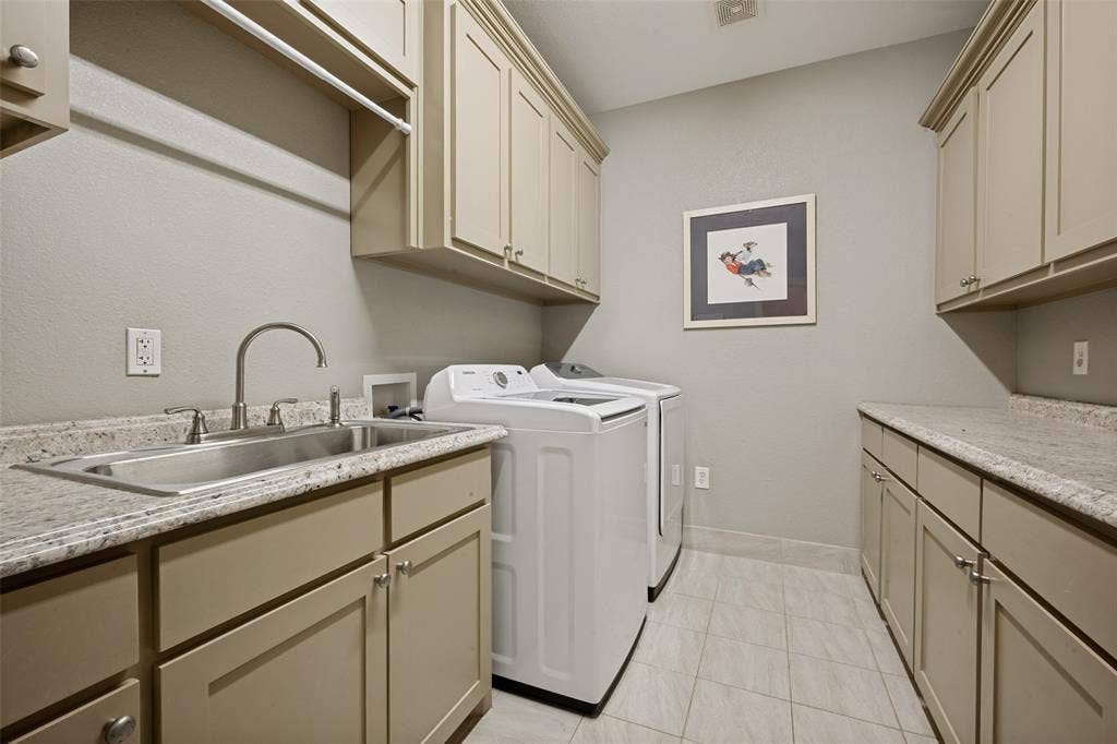 8400 Holder Road, Northlake, TX 76247 Laundry room featuring extensive cabinetry, a stainless steel utility sink, composite countertops, and tile flooring