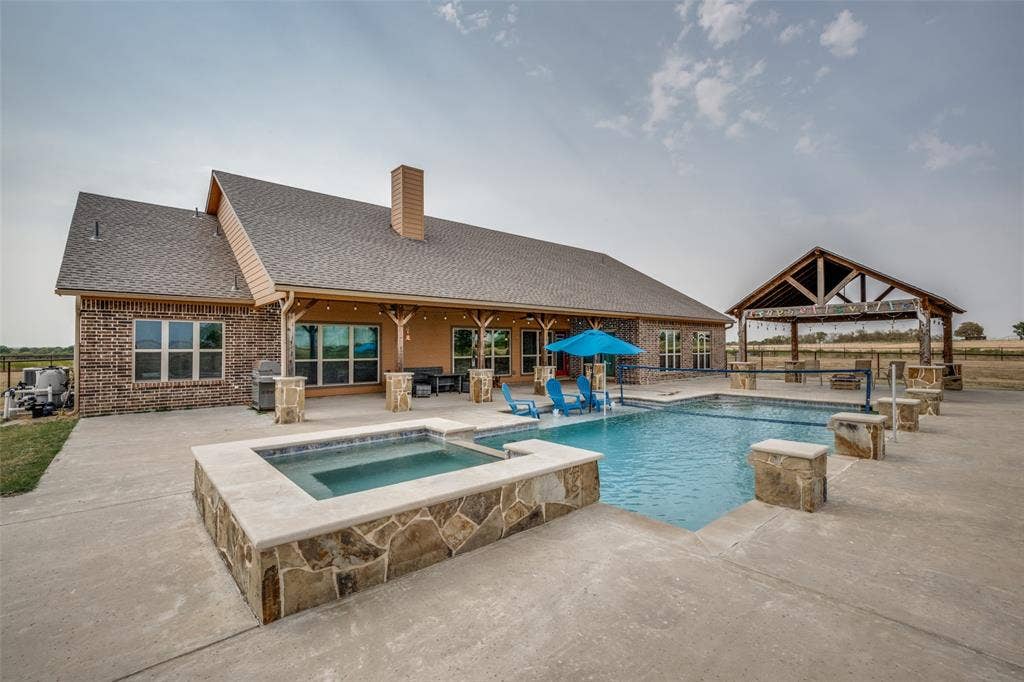 8400 Holder Road, Northlake, TX 76247 Expansive concrete patio featuring a built-in swimming pool and integrated spa