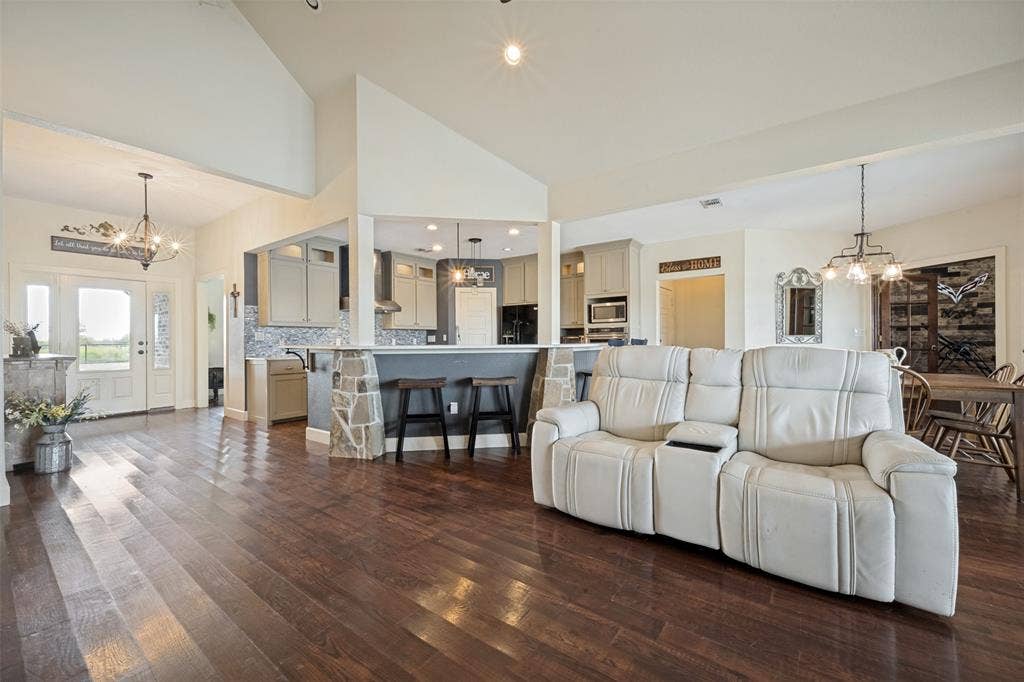 8400 Holder Road, Northlake, TX 76247 Vaulted ceilings, wood-finish flooring, kitchen with stone-accented breakfast bar, pendant lighting, and recessed lighting
