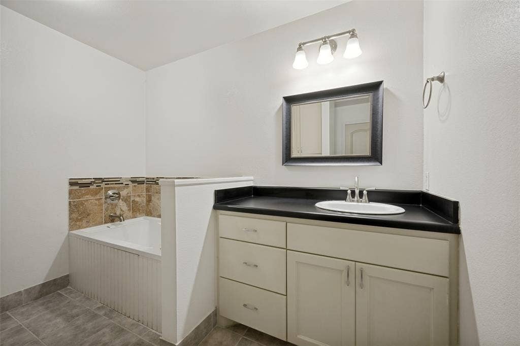 8400 Holder Road, Northlake, TX 76247 Vanity with integrated sink, dark countertop, and brushed nickel faucet