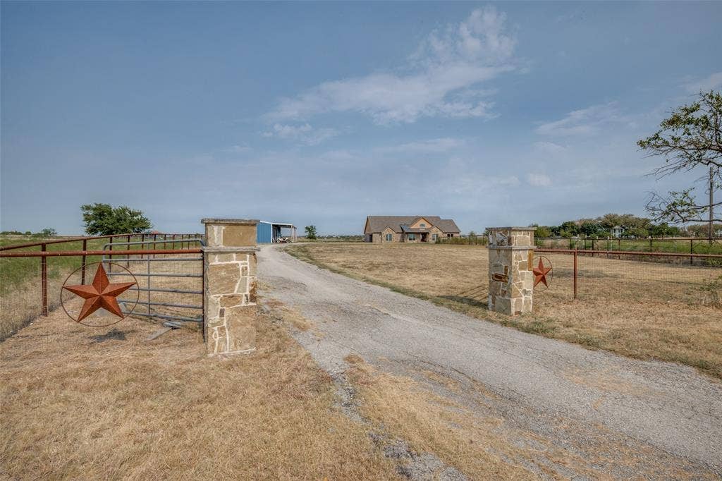 8400 Holder Road, Northlake, TX 76247 Gravel driveway leading to a stone exterior residence with a built-in garage
