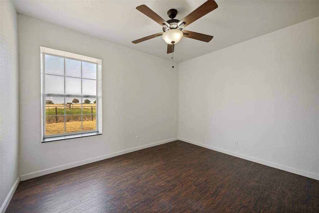 8400 Holder Road, Northlake, TX 76247 Wood-finish flooring, white painted walls, ceiling fan with integrated lighting, and a multi-pane window