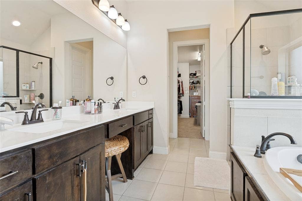 4601 Massey Meadows Way, Midlothian, TX 76065 Dual vanity with undermount sinks and dark wood-finish cabinetry, a large mirror, and overhead lighting