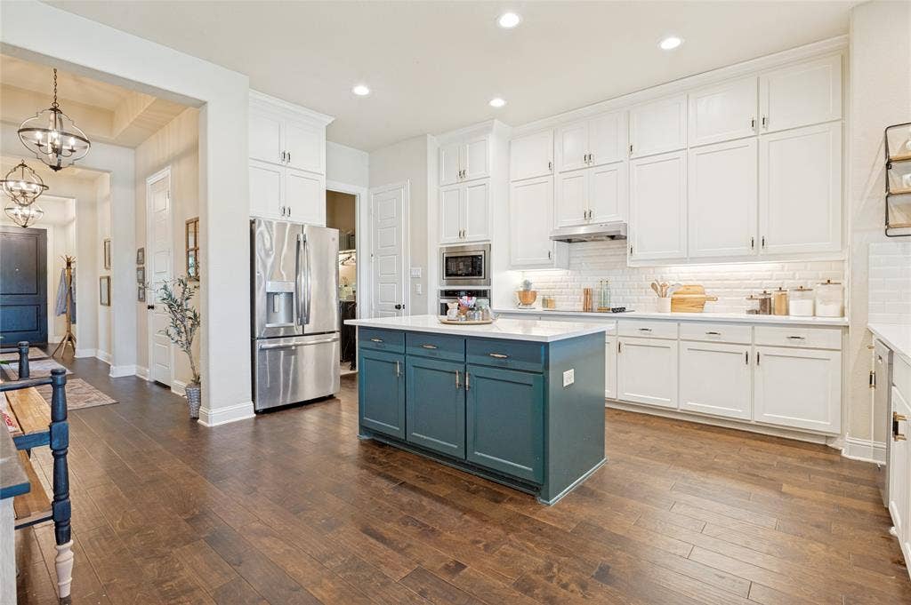 4601 Massey Meadows Way, Midlothian, TX 76065 Kitchen featuring wood-finish flooring, white cabinetry, a central island with deep blue cabinetry, stainless steel appliances, and recessed lighting