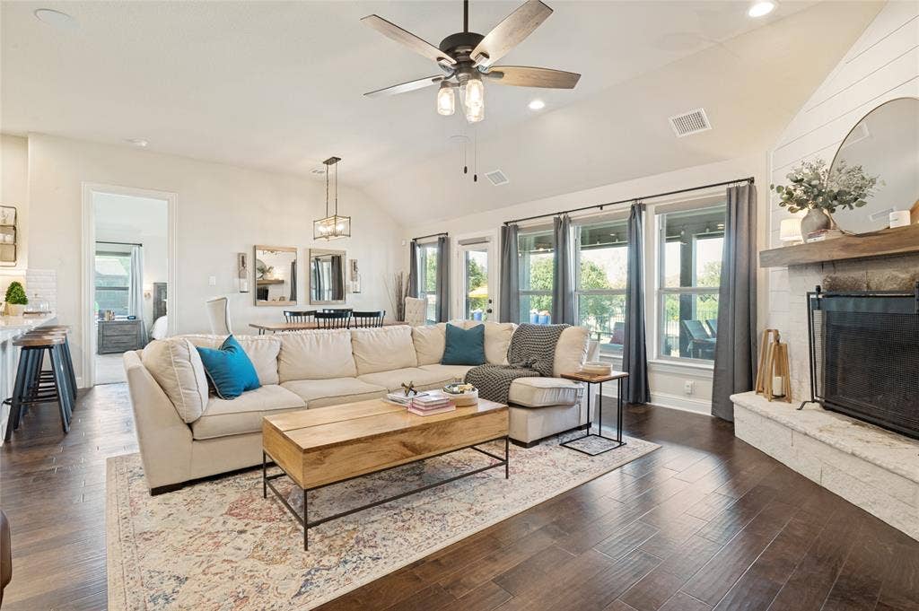 4601 Massey Meadows Way, Midlothian, TX 76065 Vaulted ceiling with a ceiling fan, recessed lighting, wood-finish flooring, fireplace with a shiplap accent wall, and multiple large windows