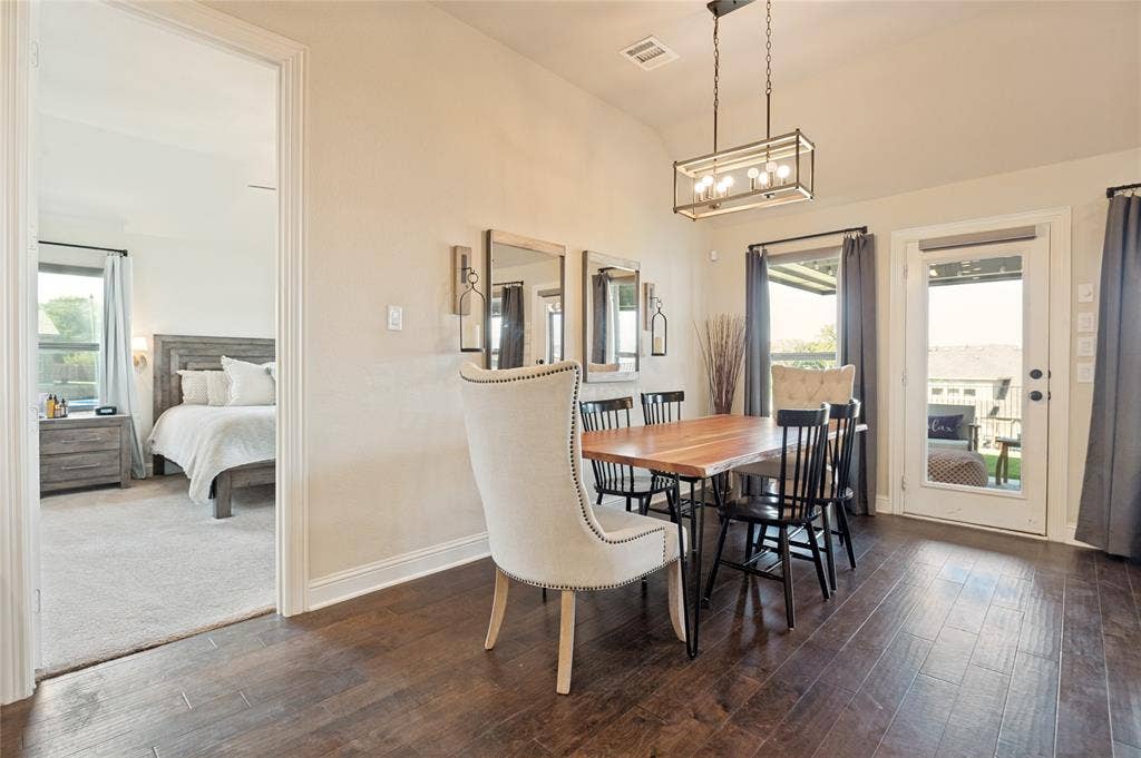 4601 Massey Meadows Way, Midlothian, TX 76065 Dining area with wood-finish flooring, a rectangular chandelier, and an exterior door leading to an outdoor space