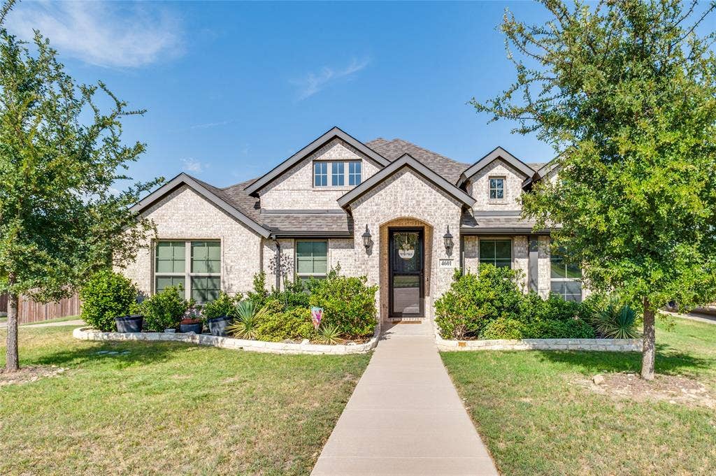 4601 Massey Meadows Way, Midlothian, TX 76065 Brick facade with dark trim, arched entryway, gabled roofline, front landscaping, and a concrete pathway