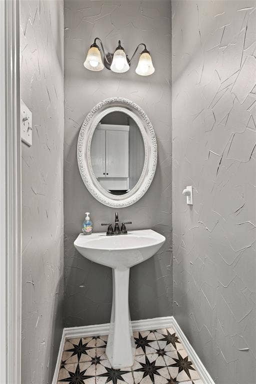 1820 Forest Bend Lane, Keller, TX 76248 Downstairs guest bathroom with pedestal sink with dark-toned fixtures.