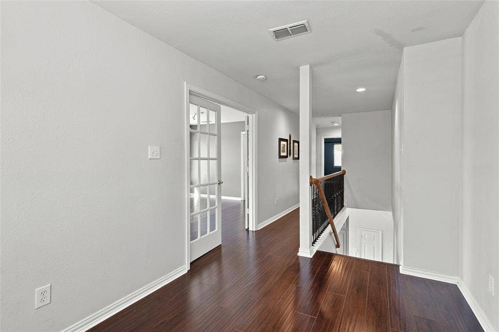 1820 Forest Bend Lane, Keller, TX 76248 Bright upper level featuring durable wood plank laminate flooring throughout, white trim, recessed lighting, and a staircase with a dark wrought iron and wood banister.