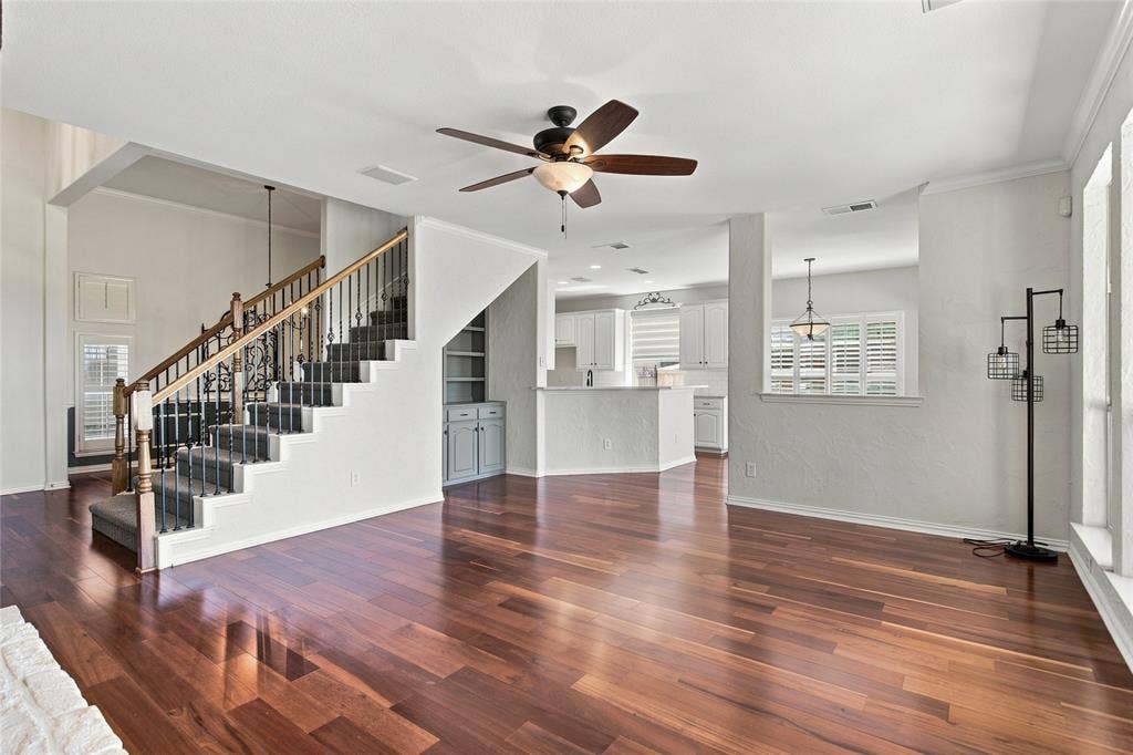 1820 Forest Bend Lane, Keller, TX 76248 Living room and staircase with wrought iron balusters, built-in cabinetry, and ceiling fan