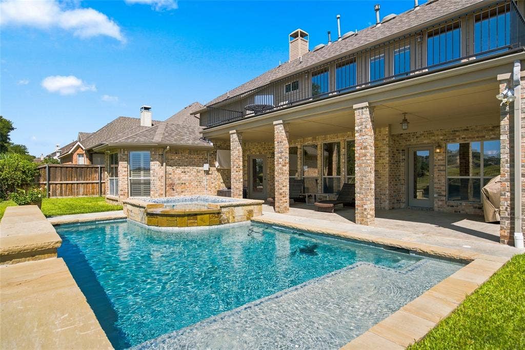 1820 Forest Bend Lane, Keller, TX 76248 Brick exterior with a covered patio, featuring a built-in pool and integrated spa.