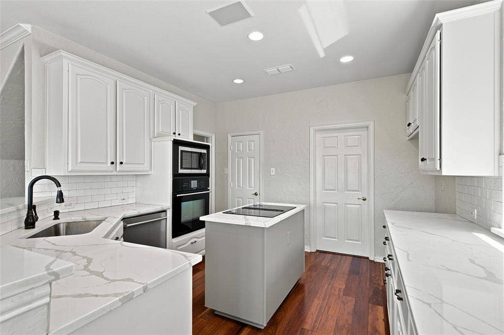 1820 Forest Bend Lane, Keller, TX 76248 White cabinetry, quartz countertops, subway tile backsplash, stainless steel appliances, and a central island with a cooktop.