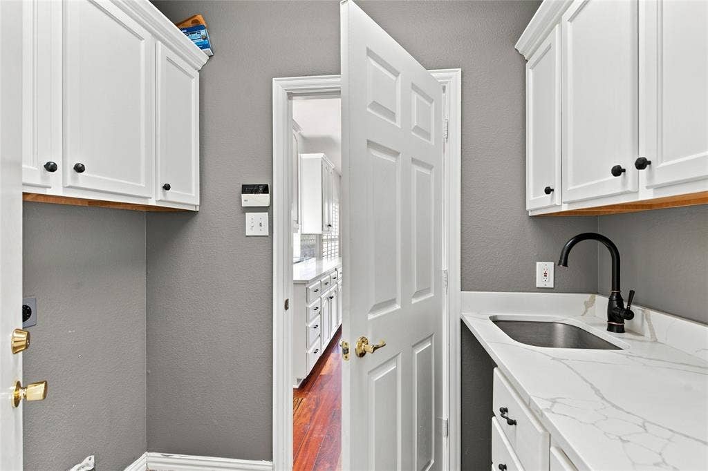 1820 Forest Bend Lane, Keller, TX 76248 White shaker-style cabinetry with black hardware, white quartz countertop with integrated sink, and black faucet.