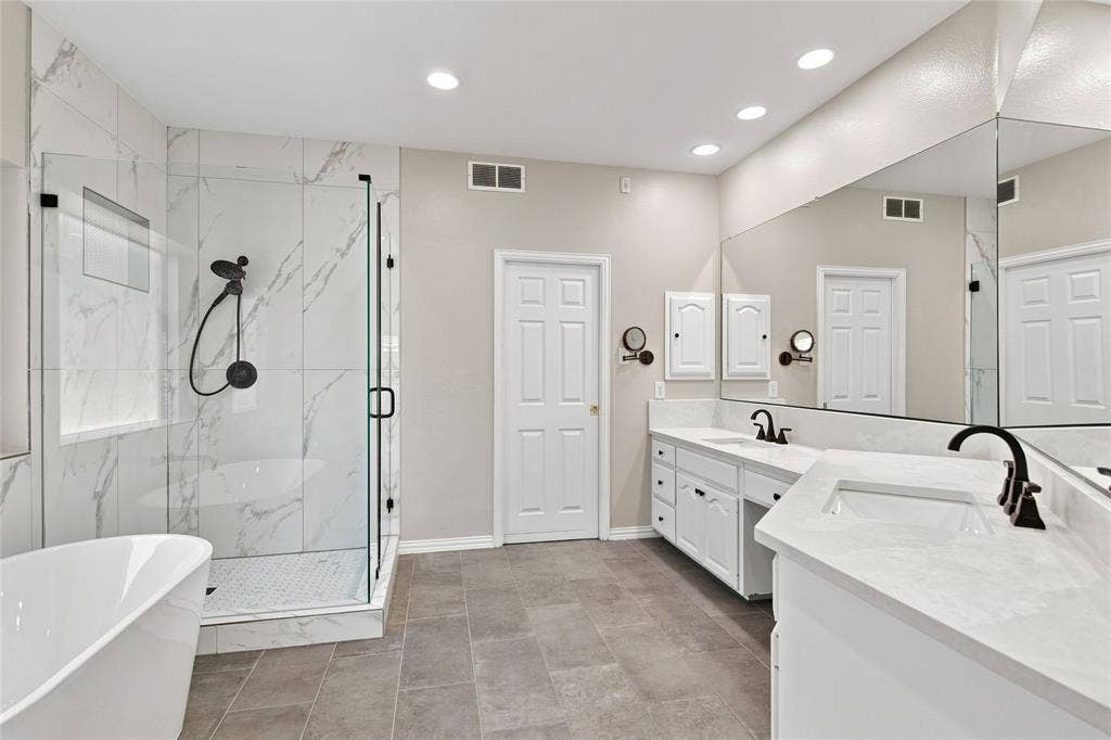 1820 Forest Bend Lane, Keller, TX 76248 Walk-in shower with clear glass enclosure and tile surround, freestanding soaking tub, dual vanity with undermount sinks, and large wall-mounted mirror.
