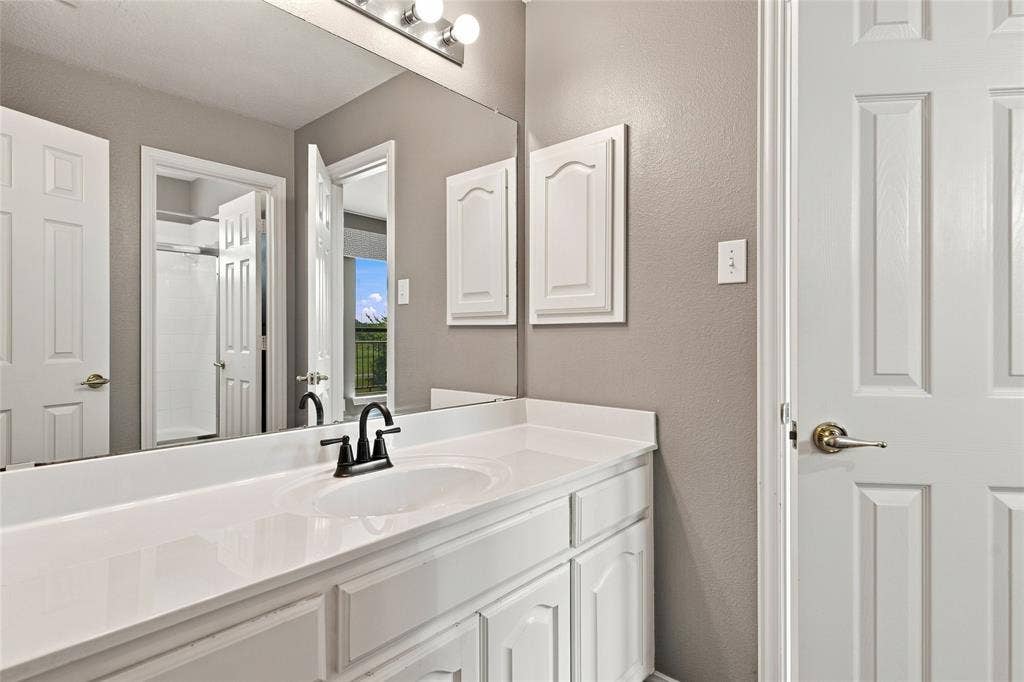 1820 Forest Bend Lane, Keller, TX 76248 Vanity with integrated sink, white countertop, white cabinetry, and a full-width mirror.