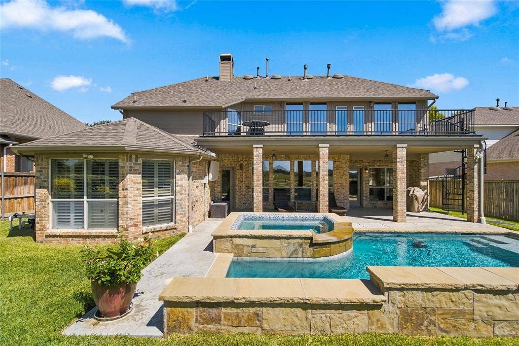 1820 Forest Bend Lane, Keller, TX 76248 Expansive brick exterior with a second-story balcony, a covered patio, a built-in swimming pool, staircase to balcony and an integrated spa.