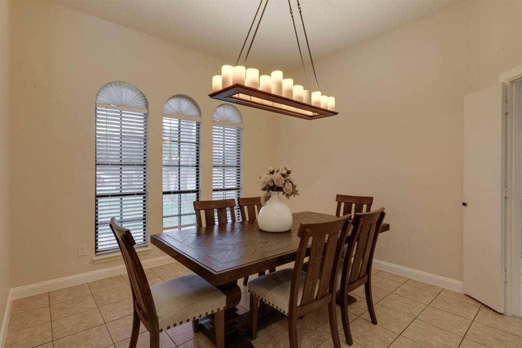 1408 Quapaw Trail, Mesquite, TX 75149 Vaulted ceiling, tile flooring, arched windows, and a rectangular chandelier