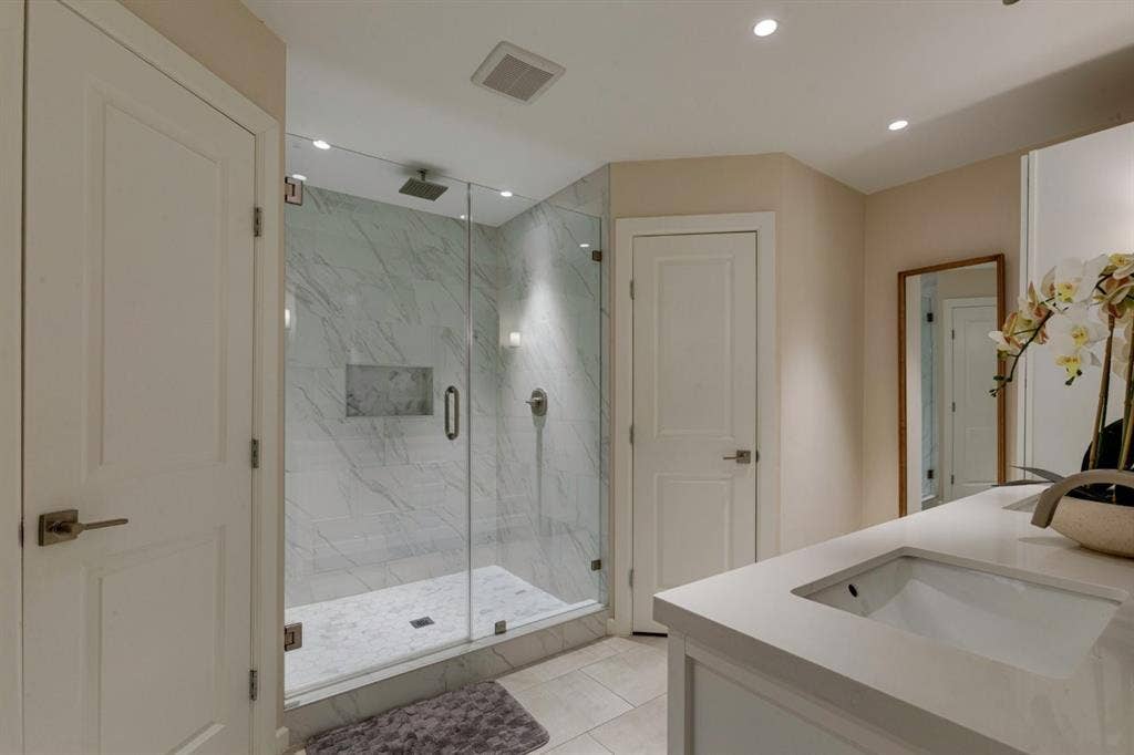 1408 Quapaw Trail, Mesquite, TX 75149 Glass-enclosed shower with marble-finish tile, integrated shower niche, and a rain shower head