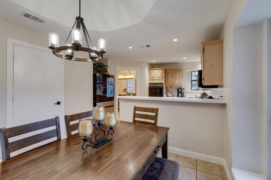 1408 Quapaw Trail, Mesquite, TX 75149 Tray ceiling with a decorative chandelier, recessed lighting, and a kitchen pass-through