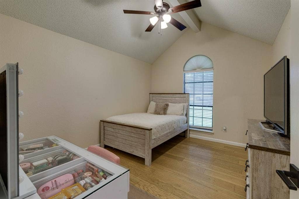 1408 Quapaw Trail, Mesquite, TX 75149 Vaulted ceiling with exposed beam, wood-finish flooring, ceiling fan with integrated lighting, and an arched window