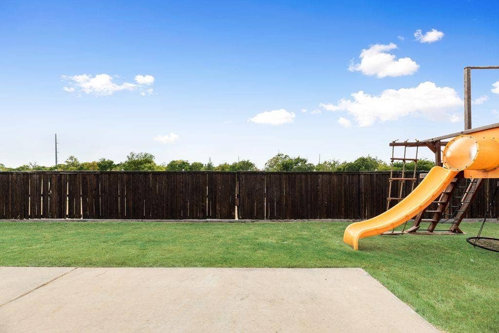 259 Saddlebrook Lane, Waxahachie, TX 75165 Expansive backyard featuring a manicured lawn, a full-height privacy fence, and a concrete patio