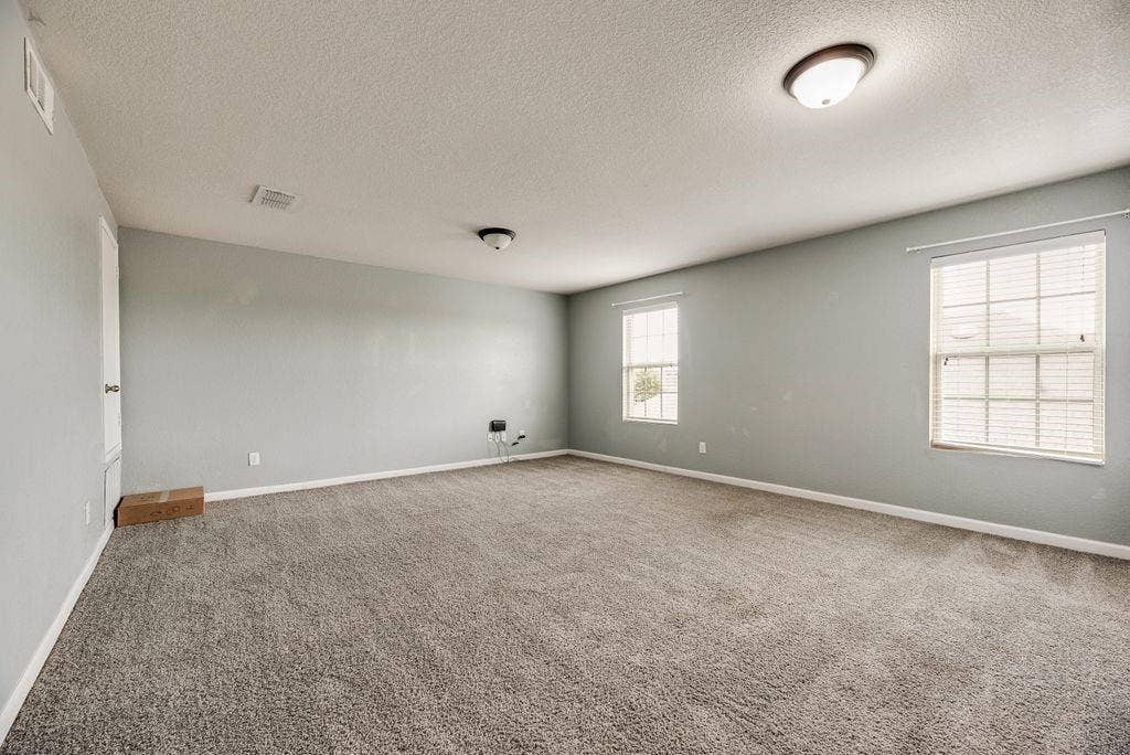 259 Saddlebrook Lane, Waxahachie, TX 75165 Spacious room featuring neutral wall finishes, recessed ceiling lighting, carpet flooring, and dual windows with plantation shutters providing natural illumination