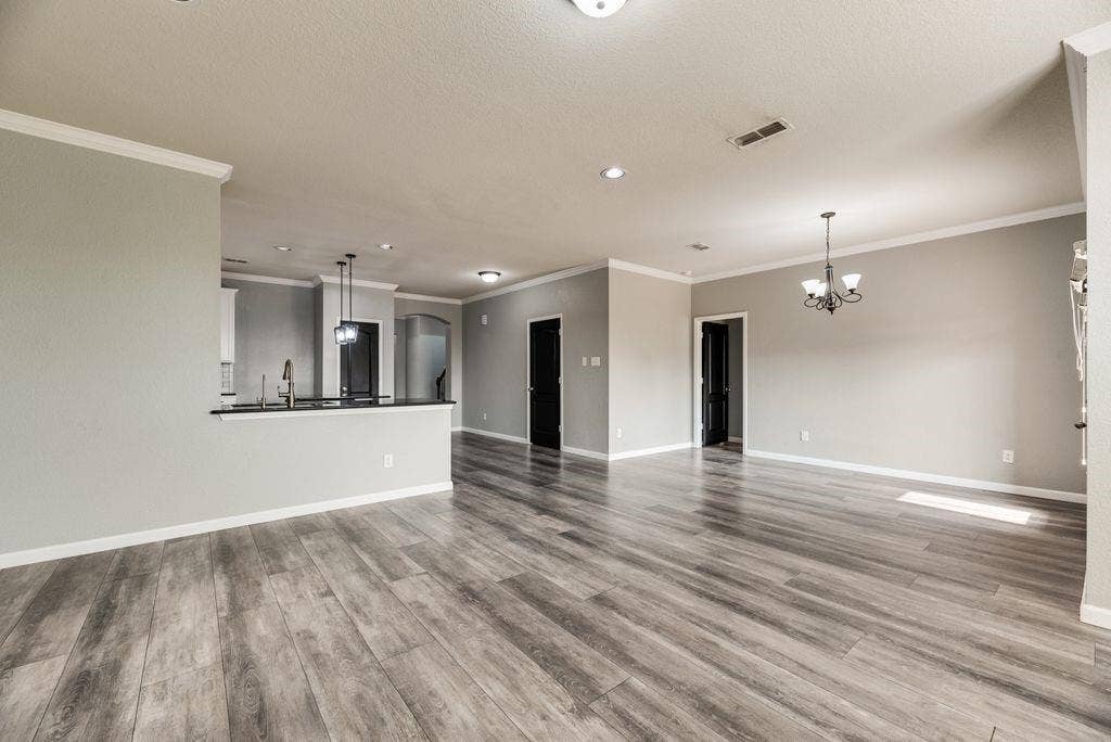 259 Saddlebrook Lane, Waxahachie, TX 75165 Wood-finish flooring, recessed lighting, crown molding, and a kitchen pass-through with a built-in sink