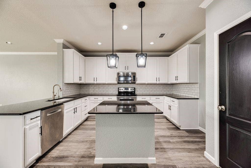 259 Saddlebrook Lane, Waxahachie, TX 75165 Kitchen featuring white cabinetry, dark countertops, a subway tile backsplash, stainless steel appliances, and wood-finish flooring
