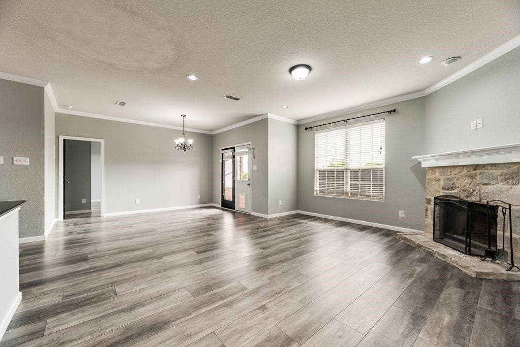 259 Saddlebrook Lane, Waxahachie, TX 75165 Wood-finish flooring, stone-surround fireplace, recessed lighting, crown molding, and a chandelier fixture