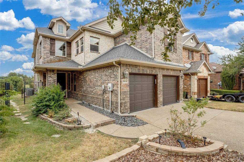 1014 Kaylie Street, Grand Prairie, TX 75052 Brick exterior with stone accents, dormer windows, and a two-car garage
