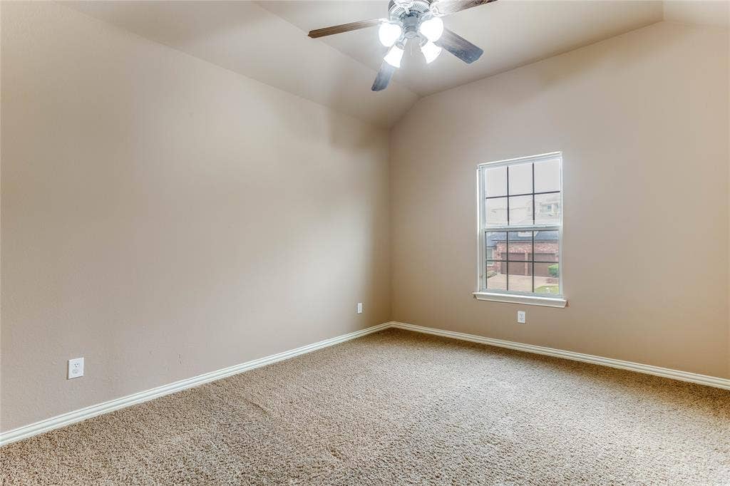 1014 Kaylie Street, Grand Prairie, TX 75052 Vaulted ceiling, ceiling fan, single window with grid pattern, neutral-toned walls, and carpet flooring