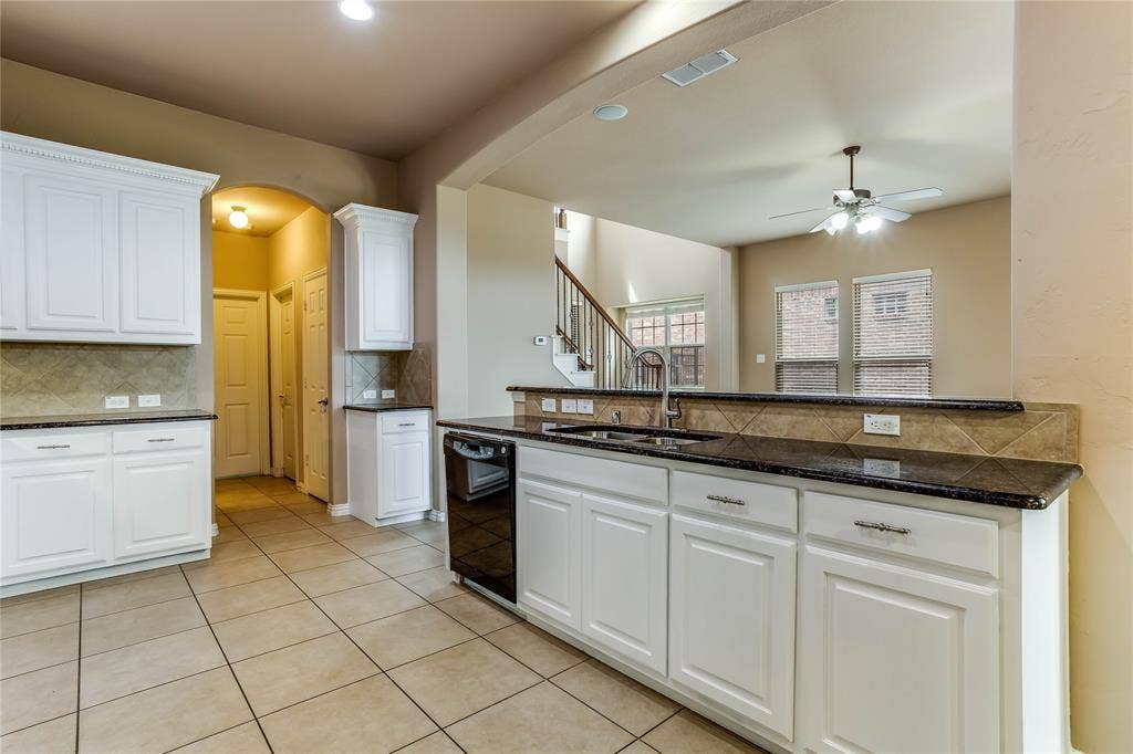 1014 Kaylie Street, Grand Prairie, TX 75052 Kitchen featuring white cabinetry, dark countertops, a tile backsplash, and tile flooring