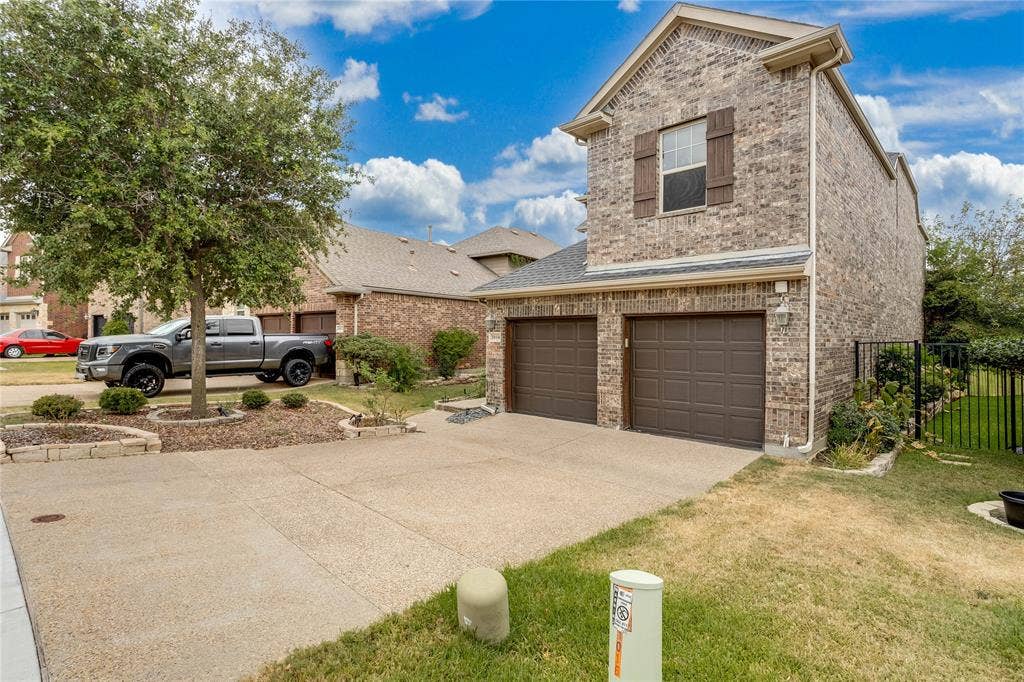 1014 Kaylie Street, Grand Prairie, TX 75052 Brick facade residence with a two-car garage, concrete driveway, and established landscaping