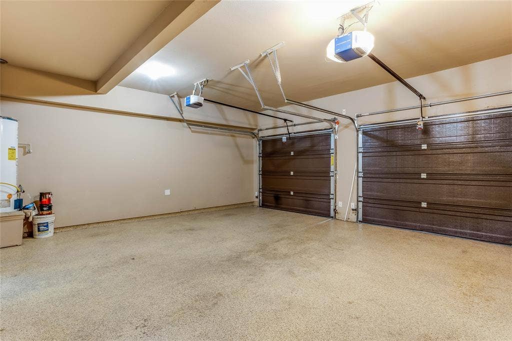 1014 Kaylie Street, Grand Prairie, TX 75052 Two-car garage featuring automatic openers, textured doors, and a durable speckled floor finish