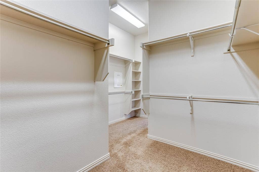 1014 Kaylie Street, Grand Prairie, TX 75052 Spacious walk-in closet with built-in shelving, hanging rods, and neutral-toned carpeting