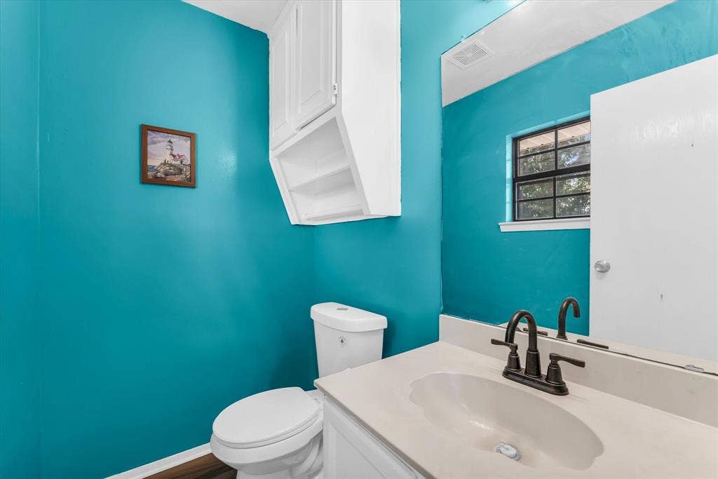 261 Oakview Circle, Waco, TX 76705 Bathroom featuring a single vanity with an integrated sink, dark bronze-finish faucet, and a wall-mounted mirror