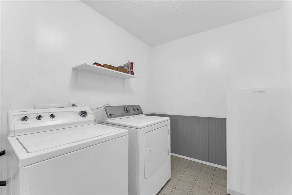 261 Oakview Circle, Waco, TX 76705 Laundry area featuring tile flooring, wainscoting, and an integrated shelf