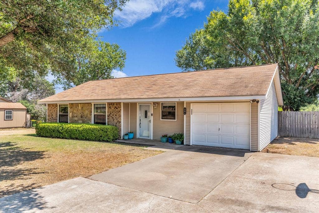 261 Oakview Circle, Waco, TX 76705 Single-story residence featuring a shingle roof, attached garage, stone facade accents, and a front porch
