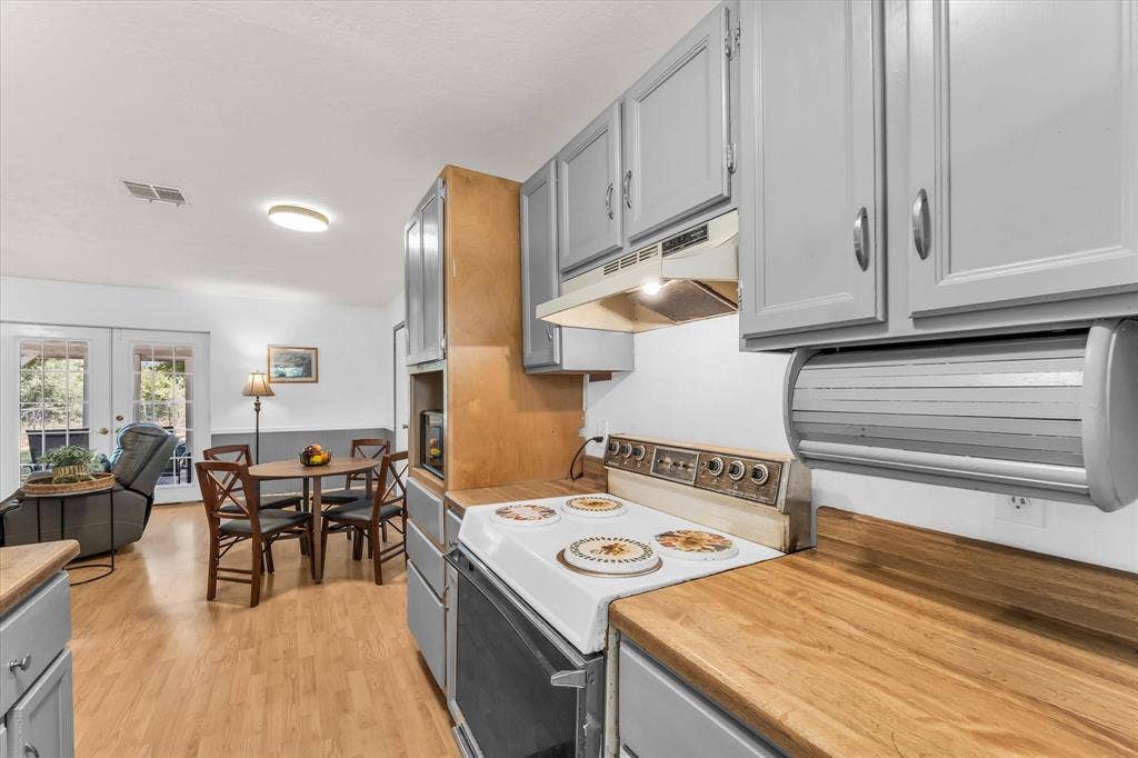 261 Oakview Circle, Waco, TX 76705 Kitchen featuring wood-finish countertops, grey cabinetry, and an electric range
