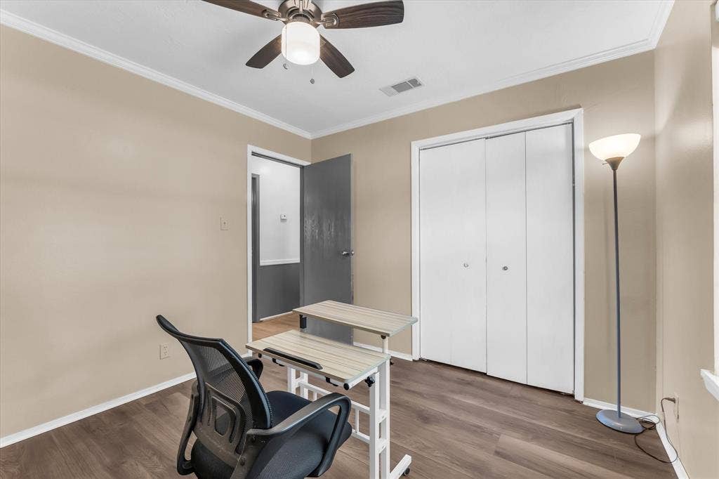 261 Oakview Circle, Waco, TX 76705 Wood-finish flooring, ceiling fan, white bi-fold closet doors, and crown molding