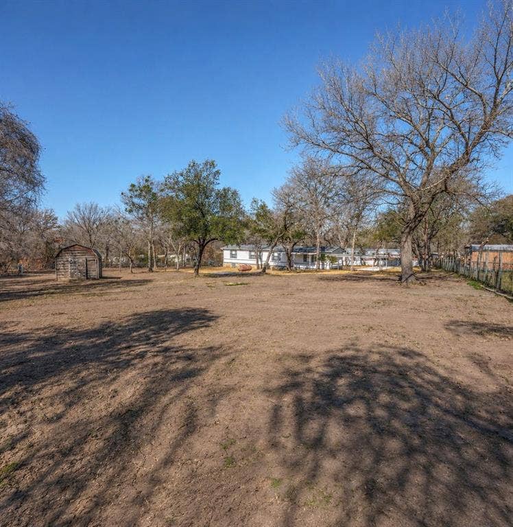 6048 Hidden Circle, Azle, TX 76020 Expansive lot with mature trees and a rustic wood outbuilding