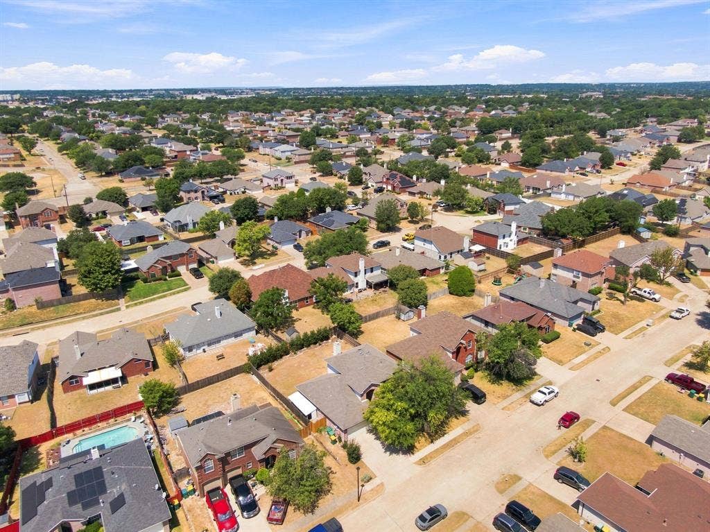 Residential neighborhood featuring single-story and two-story homes with mature trees and paved streets