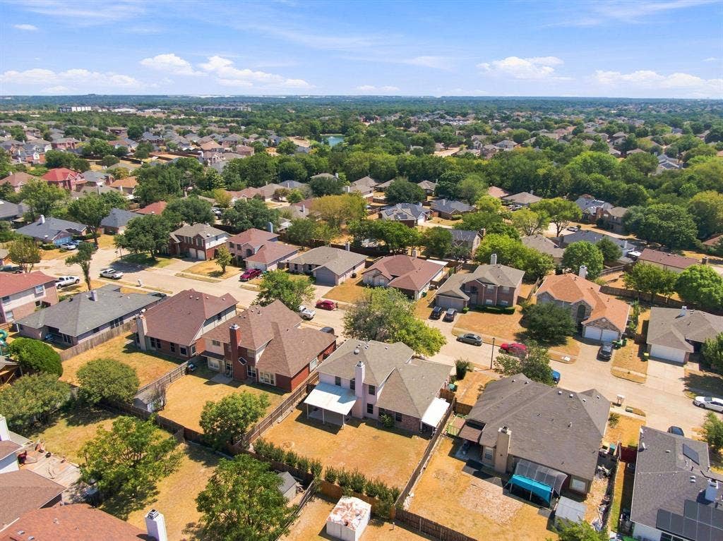 Expansive residential area featuring numerous mature trees and a clear blue sky