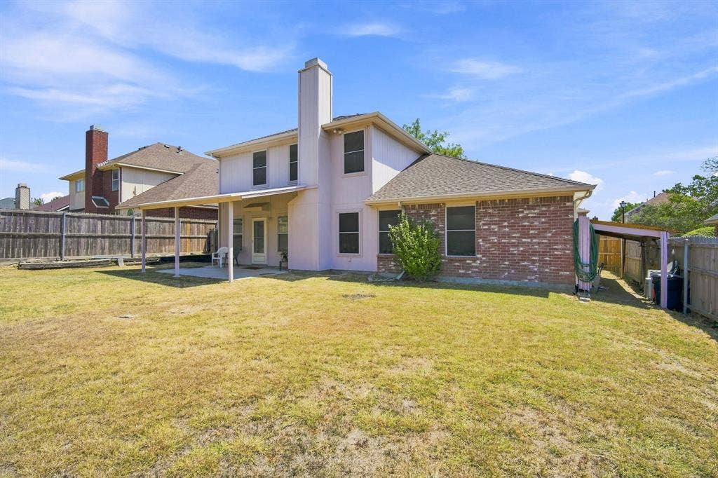 Expansive backyard with a covered patio, a brick exterior section, and a dedicated covered side storage area