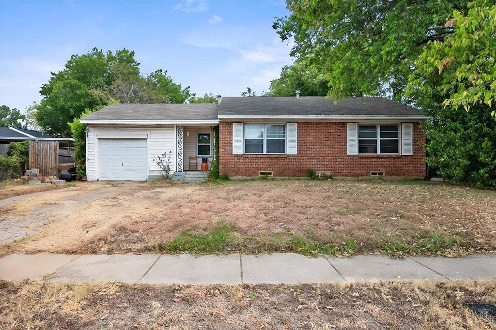 1405 Grace Street, Arlington, TX 76010 Brick facade exterior with an attached garage, white garage door, and a concrete sidewalk