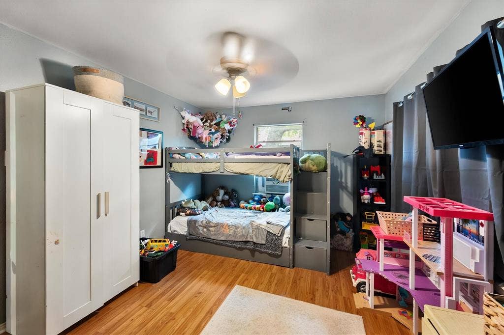 1405 Grace Street, Arlington, TX 76010 Wood-finish flooring, ceiling fan, built-in bunk bed with integrated storage, and window with natural light