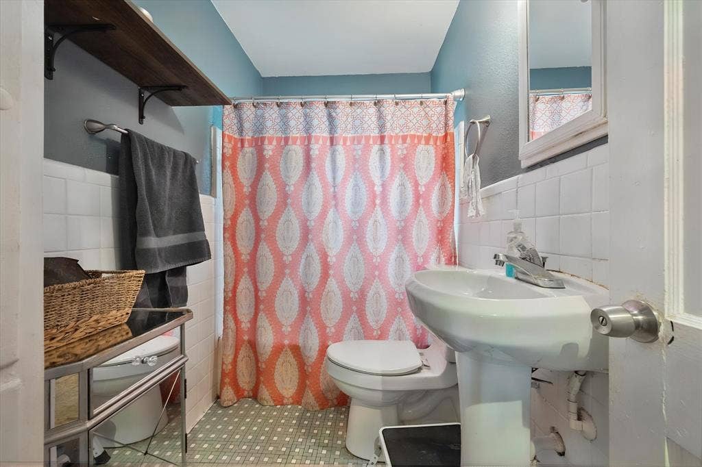 1405 Grace Street, Arlington, TX 76010 Pedestal sink with chrome faucet, white tiled walls, and mosaic-style flooring